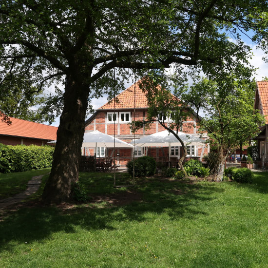 Hochzeiten in Burgwedel-Blick auf die Terrasse des Landhauses Burgwedel und einen Baum mit einer Schaukel